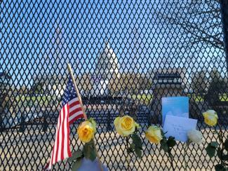 Flowers and notes of encouragement pinned to a fence outside the U.S. Capitol. | Andy Kratochvil